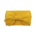 Mustard yellow waffle knit baby headband featuring a large textured fabric bow design - Turmeric