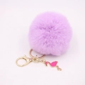 Purple faux fur pompom keychain with pink flamingo charm and gold hardware on white background - Taro Purple