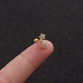 Macro detail of gold-plated triple star stud earrings with zircon inlay on fingertip - Gold Triple Star Style (Gold 3#)
