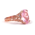 Detail of rose gold filigree ring featuring an oval pink gemstone and white side stones - US 7 / Rose Gold