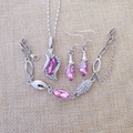 Detailed overhead shot of pink crystal angel jewelry set on a natural linen background - Silver and Rose Red
