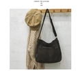 Detalle del bolso bandolera de lona negra con correa ajustable y bolsillo exterior - Negro