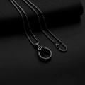 Vue macro d'un pendentif main tenant un anneau sur une chaîne hip hop noire pour homme - Main Tenant une Bague + Chaîne en Acier Inoxydable