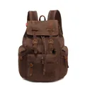 Vintage dark brown canvas backpack with leather straps and metal buckles in studio shot - Coffee