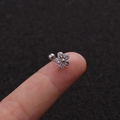 Dettaglio di un piercing tragus a fiore in argento con zirconi sulla punta delle dita - Stile Fiore d'Argento (Argento 1#)