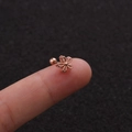 Close-up of rose gold five-petal flower stud earring with screw-back ball closure on fingertip - Rose Gold Flower Style (Rose Gold 1#)
