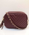 Detail of burgundy quilted faux leather crossbody bag with gold chain and fringe tassel - Burgundy