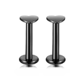 Macro detail of black heart-shaped stainless steel labret studs with polished finish - Heart / Black