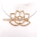 Elegant hollow lotus gold hair clip with a hammered metal texture on white marble - Lotus