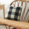 Black and white checkered linen throw pillow cover on a rustic rattan chair - Black and White Plaid