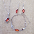 Detail view of silver jewelry set with red marquise gems and rhinestones on beige linen - Silver Lotus Red