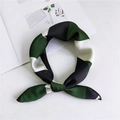 Elegant green, black and white silk scarf with geometric pattern flat lay on desk - Cross Green
