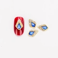 Blauer Nagelkunst-Charm in Rautenform mit Kristallrand und goldener Basis auf rotem Nagel - Königsblau mit AB Strass (1564)