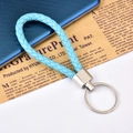 Sky blue braided leather keychain with polished silver metal ring on vintage background - Light Blue
