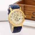 Detailed close-up of a vintage skeleton watch with blue leather strap and golden case - Gold Face Blue Strap