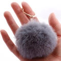 Soft grey faux rabbit fur keychain with a gold metal ring held in hand for display - 7cm Pom-pom / Gray