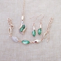 Detailed view of gold jewelry set featuring green leaf crystals and clear rhinestones - Gold Fruit Green
