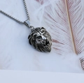 Detailed close-up of a silver lion head pendant necklace with vintage punk metal texture - Lion Head + Steel Chain