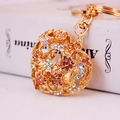 Golden heart keychain with sparkling star and moon rhinestones on a blurred book background - Individual Packaging / Peach