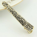 Elegante molletta dorata con strass grigi scintillanti su ceramica bianca fine - Strass Nero / Nero