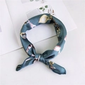Green silk square scarf with gold and pink chain print pattern tied on a book - Gem Chain Lake Blue