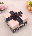 Vista dall'alto di una scatola regalo rosa e nera con motivo a cuore e fiocco - Beige
