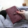 Short burgundy matte wallet with snap closure and wrist strap shown in hand - Wine Red p-04