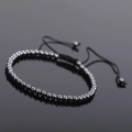 Macro detail of hematite beaded bracelet with adjustable black braided rope on black surface - Black Style 3