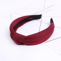 Close-up of wine red knitted headband featuring a cross knot and vertical striped texture - Burgundy