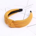 Detail of ginger yellow knitted fabric headband featuring a cross knot and anti-slip lining - Yellow