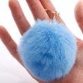 Soft light blue faux rabbit fur pompom keychain with golden clasp held in palm - 7cm Pom-pom / Sky Blue