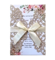 Detail of laser-cut gold glitter wedding invitation with floral pattern and silk bow - Rose Gold