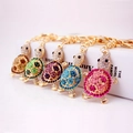 Sparkling rhinestone sea turtle keychains in five colors on a white gift box background - Random Color