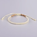 Detailed view of adjustable cream braided bracelet with colorful accents and sliding knot - Off-White Multicolor