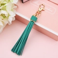 Teal PU leather tassel keychain with gold lobster clasp on a pink gift box - Green