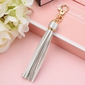Elegant silver PU leather tassel keychain with gold lobster clasp on gift box background - Silver