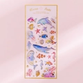 Single sheet of watercolor ocean life stickers with gold foil details on pink backdrop - Blue Whale