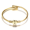 Macro detail of golden cable bracelet featuring a heart pendant engraved with letter W - Letter W / Gold