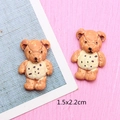 Detailed view of two brown resin bear charms for DIY crafts with 1.5x2.2cm size text - Light Coffee Bear in Yellow Clothes