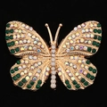 Dettaglio macro di spilla a farfalla dorata con strass colorati e perle bianche - Verde Scuro