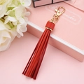 Red PU leather tassel keychain with a golden metal swivel clasp and pink gift box packaging - Red