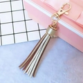Light gold faux leather tassel keychain with metallic swivel lobster clasp and fringe detail - Gold
