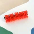 Detail view of five red resin gummy bears on a silver metal alligator hair clip - Red