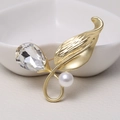 Elegant matte gold brooch with faux pearls and crystals on a white ceramic plate - 0480-Gold Ring Leaf Pearl