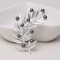 Elegant matte silver olive branch brooch with black pearl accents on a neutral surface - 0486-Silver Branch Pearl