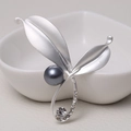 Zilveren bladvormige broche met zwarte parel en strass op witte keramische kom getoond - 0485-Zilveren Blad Parel Strass