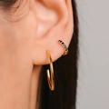 Détail d'une boucle d'oreille créole dorée et d'un faux piercing serti de zircons noirs - Plaqué Or + Zirconia Noir