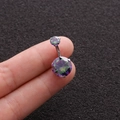 Macro detail of rainbow cubic zirconia belly button ring held between fingers - Rainbow