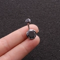 Close-up of a silver belly button ring featuring two faceted round black zircon stones - Black
