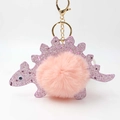 Detail of pink faux rabbit fur pom pom on a glittery purple dinosaur keychain with gold clasp - Pink